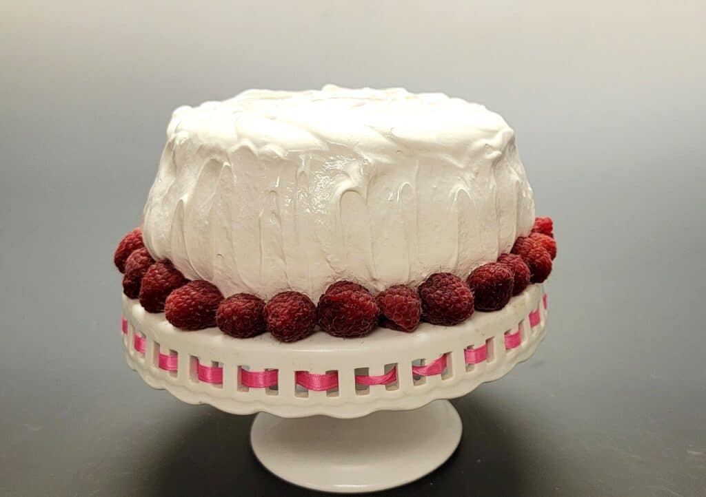 cake decorated with raspberries and marshmallow frosting