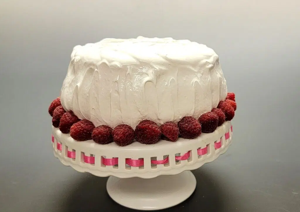 cake decorated with raspberries and marshmallow frosting
