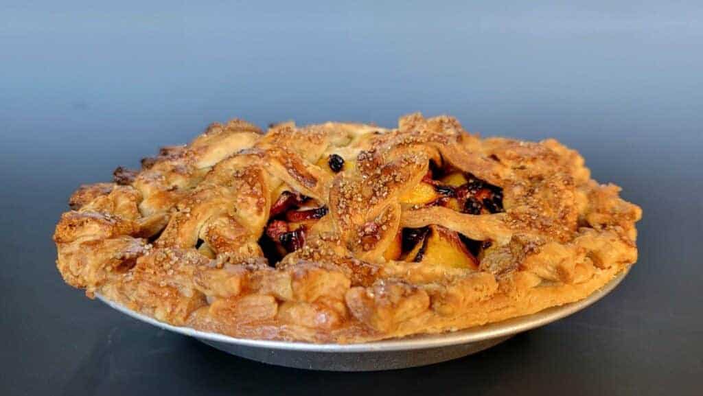 baked peach pie with flaky pie crust
