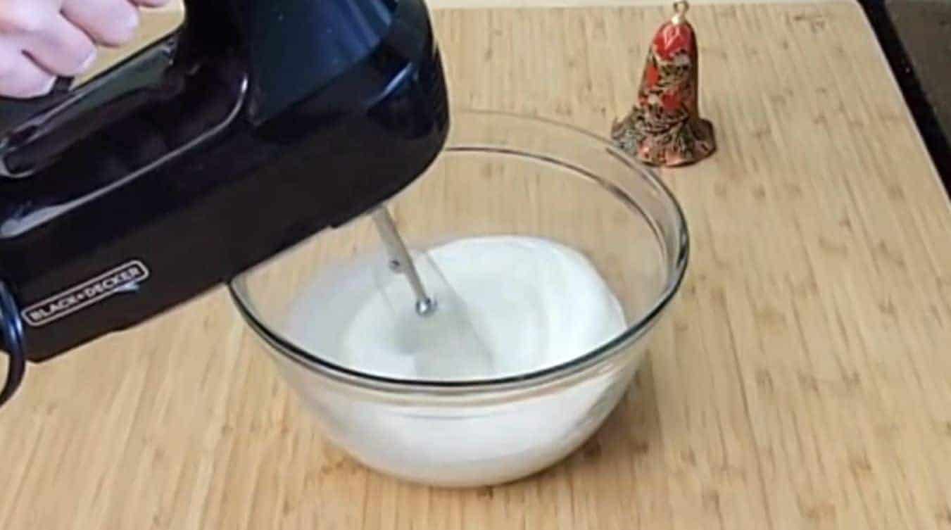 bowl of egg whites being mixed with a hand mixer