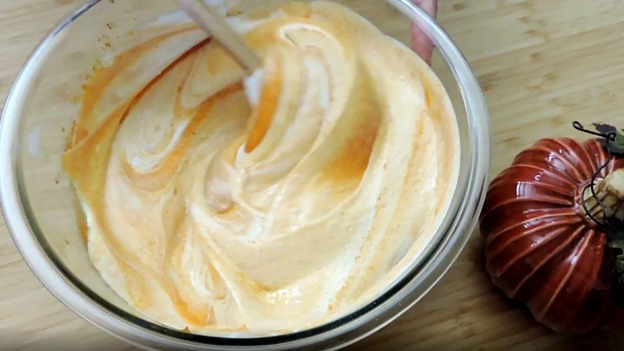 mixing pumpkin cream in a glass bowl