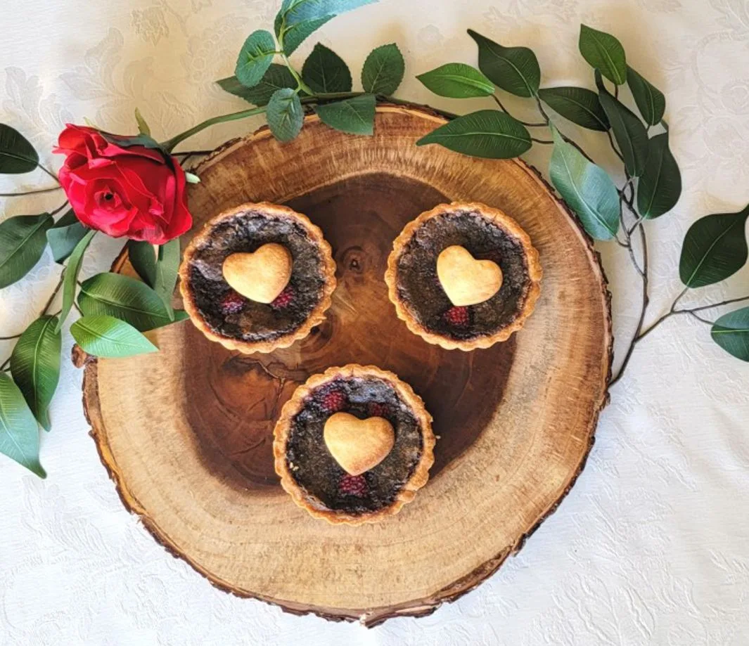 chocolate raspberry tarts on a wood slab