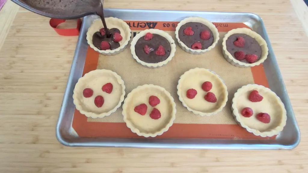 filling tart shells with raspberries and chocolate