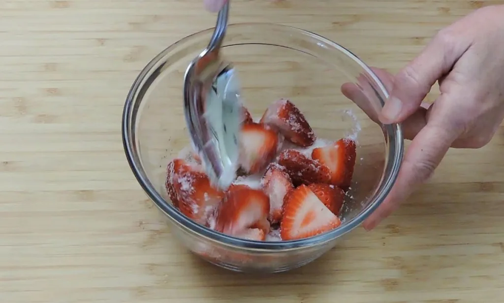 macerating strawberries in a bowl
