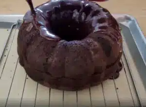 pouring glaze over chocolate cake