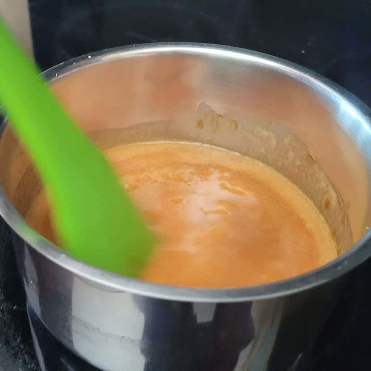 adding butter and cream to caramel