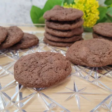 gluten free chocolate walnut cookies on a platter with flowers in background