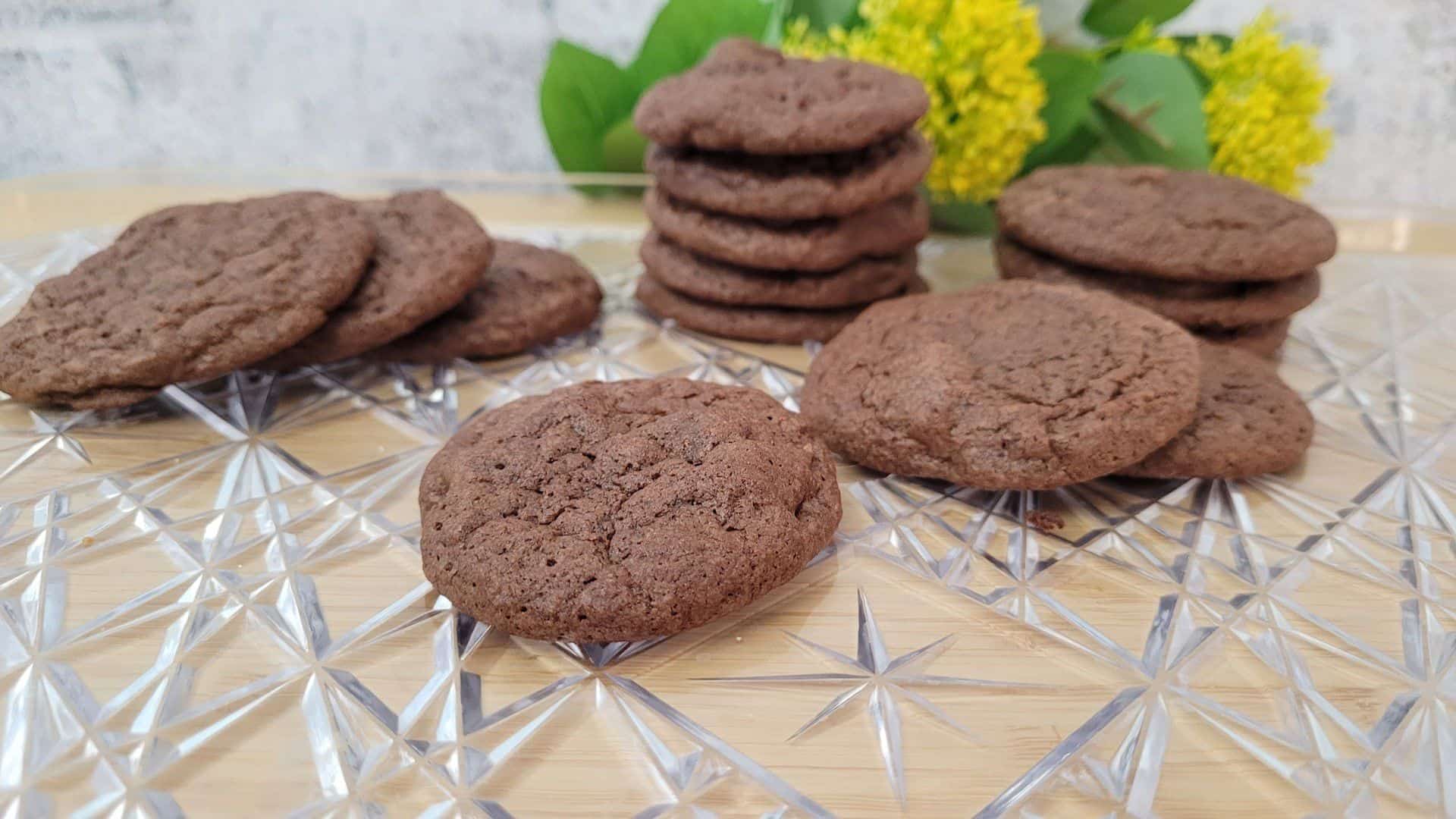 gluten free chocolate walnut cookies on a platter with flowers in background