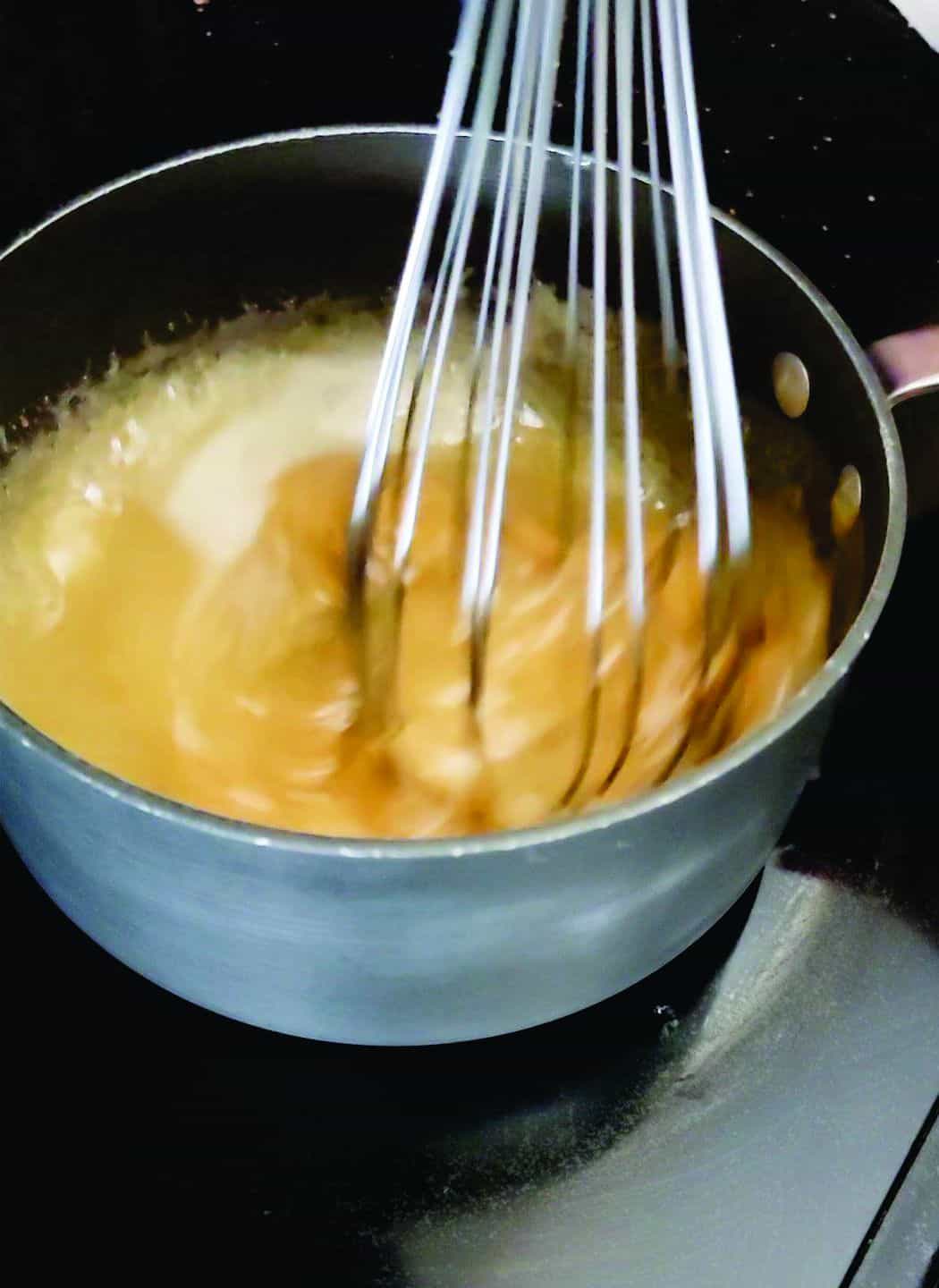 whisking peanut butter into saucepan