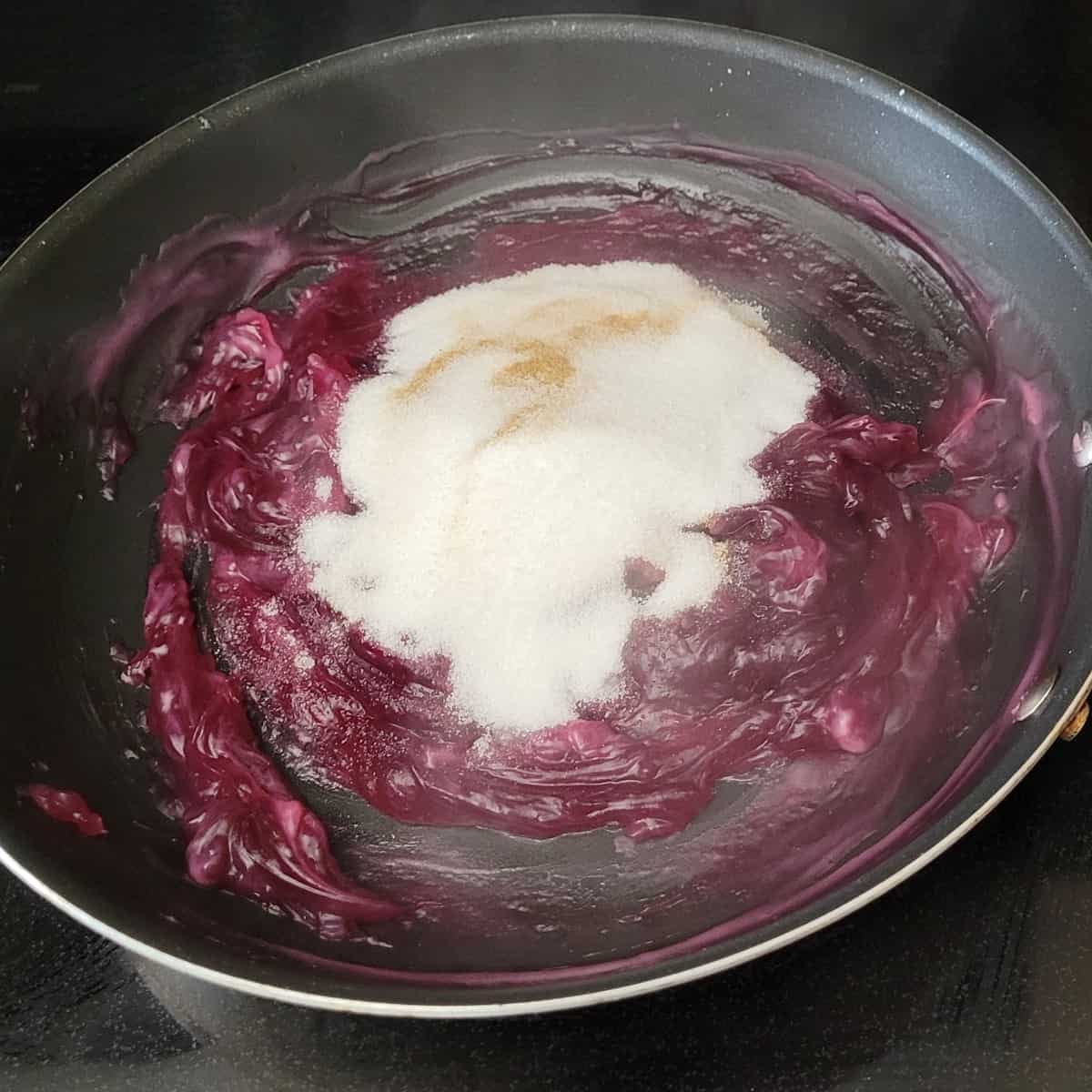 Cinnamon and sugar added to blueberry slurry saucepan