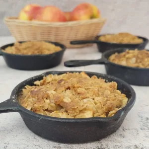 four apple crisps in small cast iron skillets for individual servings