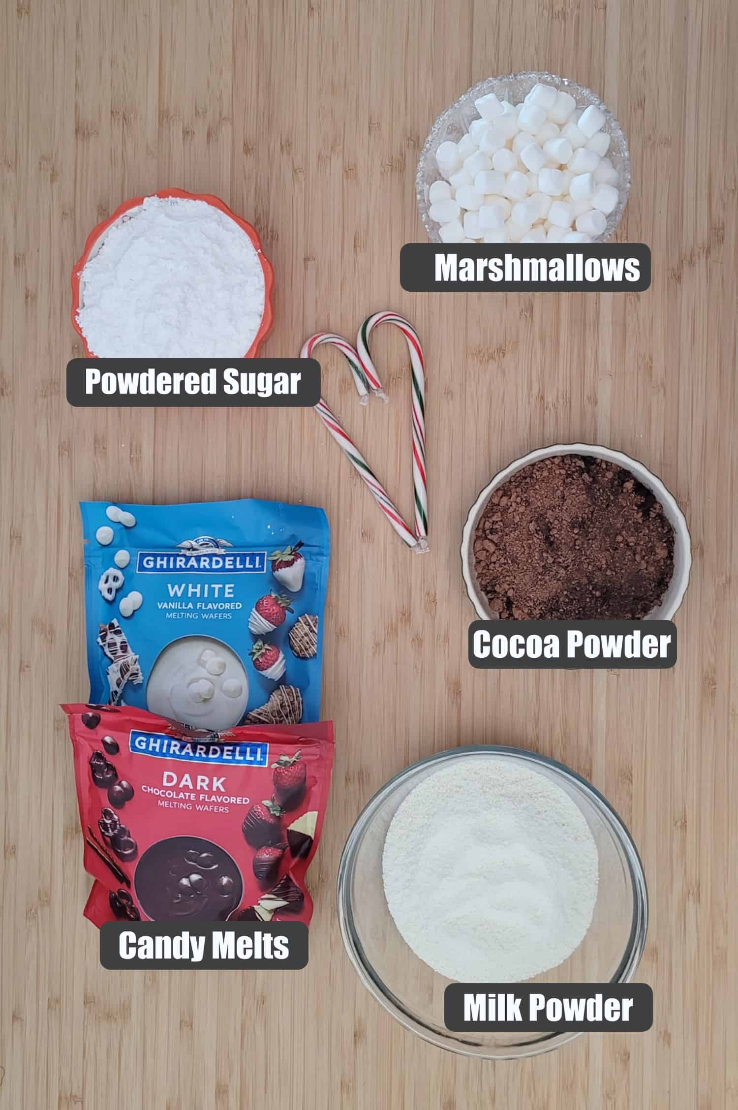 ingredients needed to make hot chocolate bombs including milk powder, candy melts, cocoa powder, powdered sugar and mini marshmallows