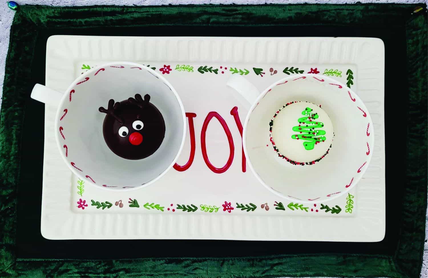 overhead view of two hot chocolate bombs in Christmas mugs