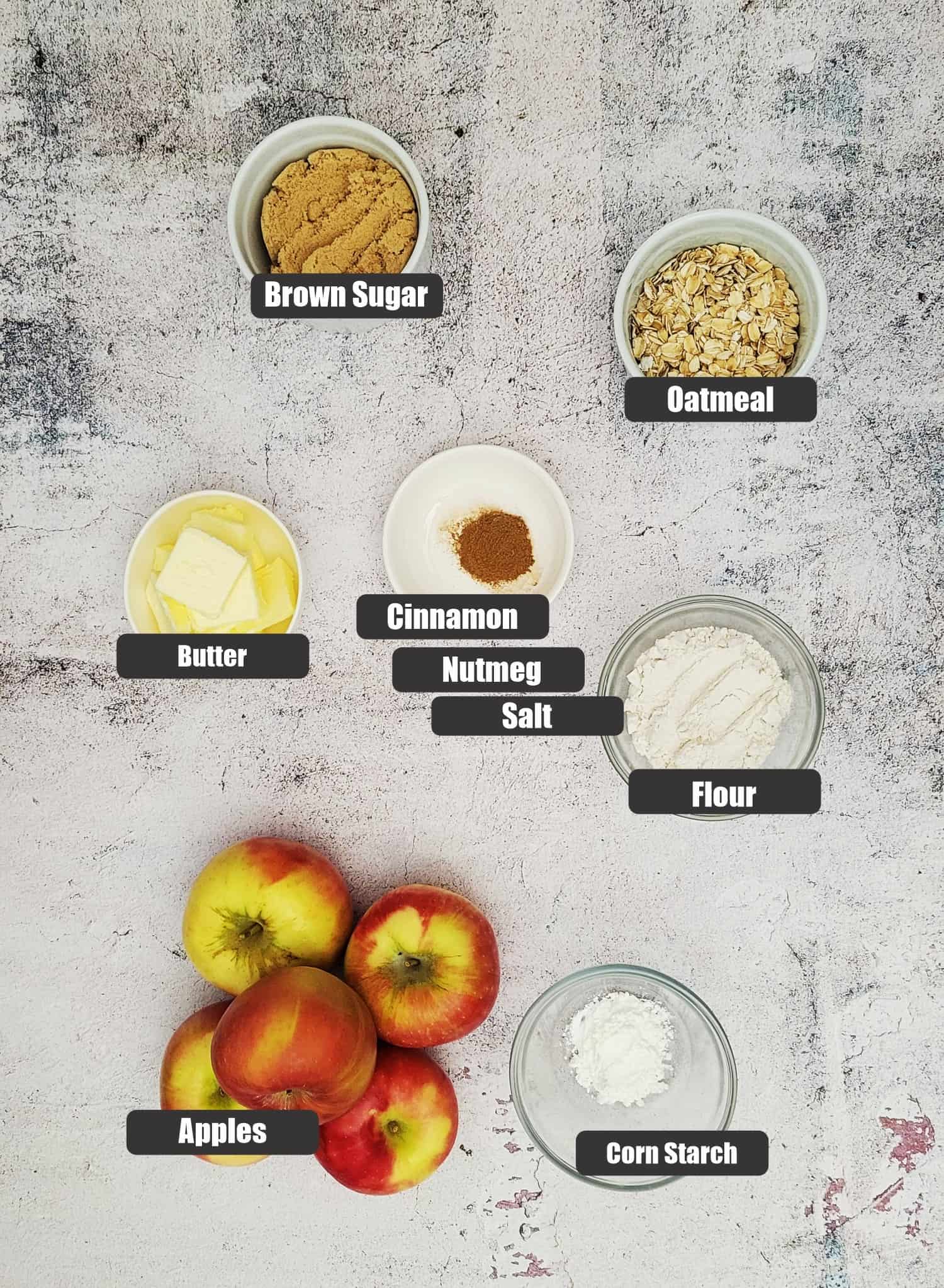 ingredients needed to make apple crisp including apples, corn starch, brown sugar, cinnamon, nutmeg, salt, oatmeal, butter and flour