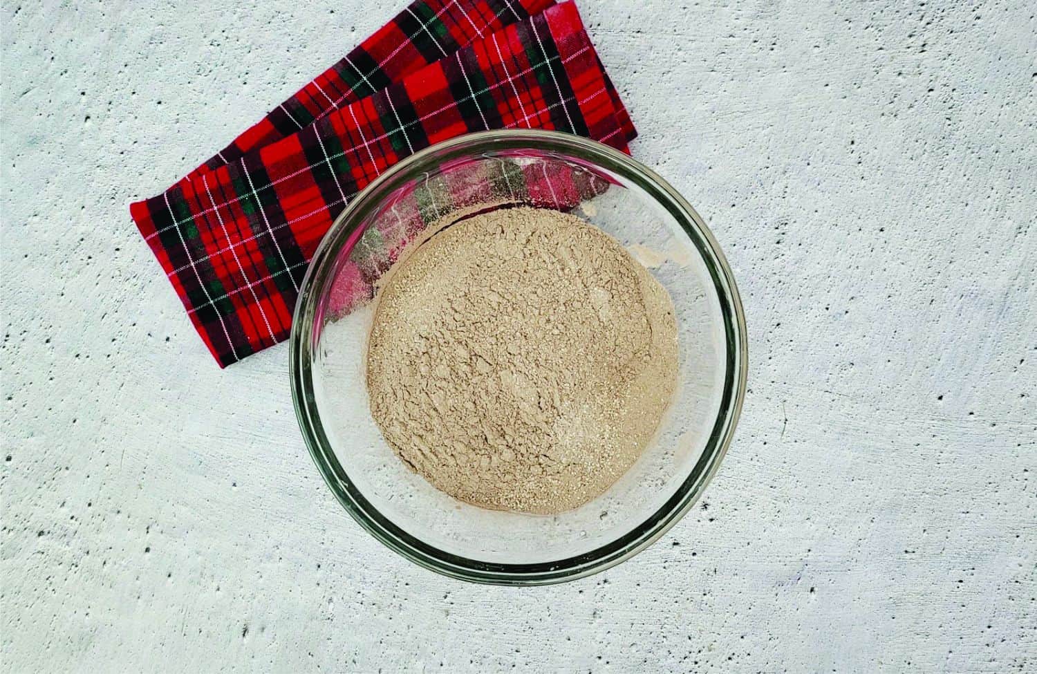 sifted ingredients in a glass bowl needed for making hot chocolate bombs