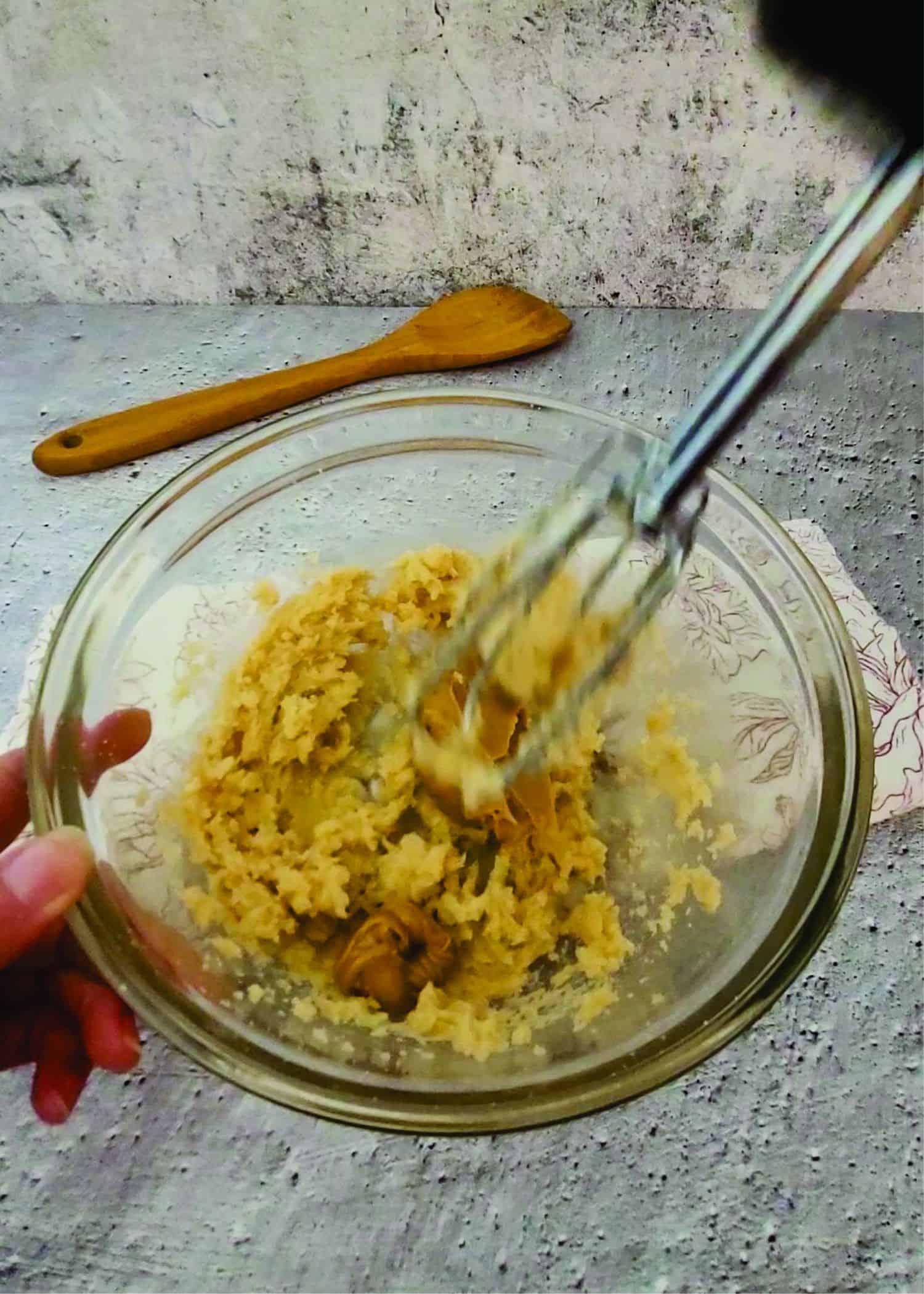 using a hand mixer to add peanut butter to cookie dough for Valentine's Day cookies