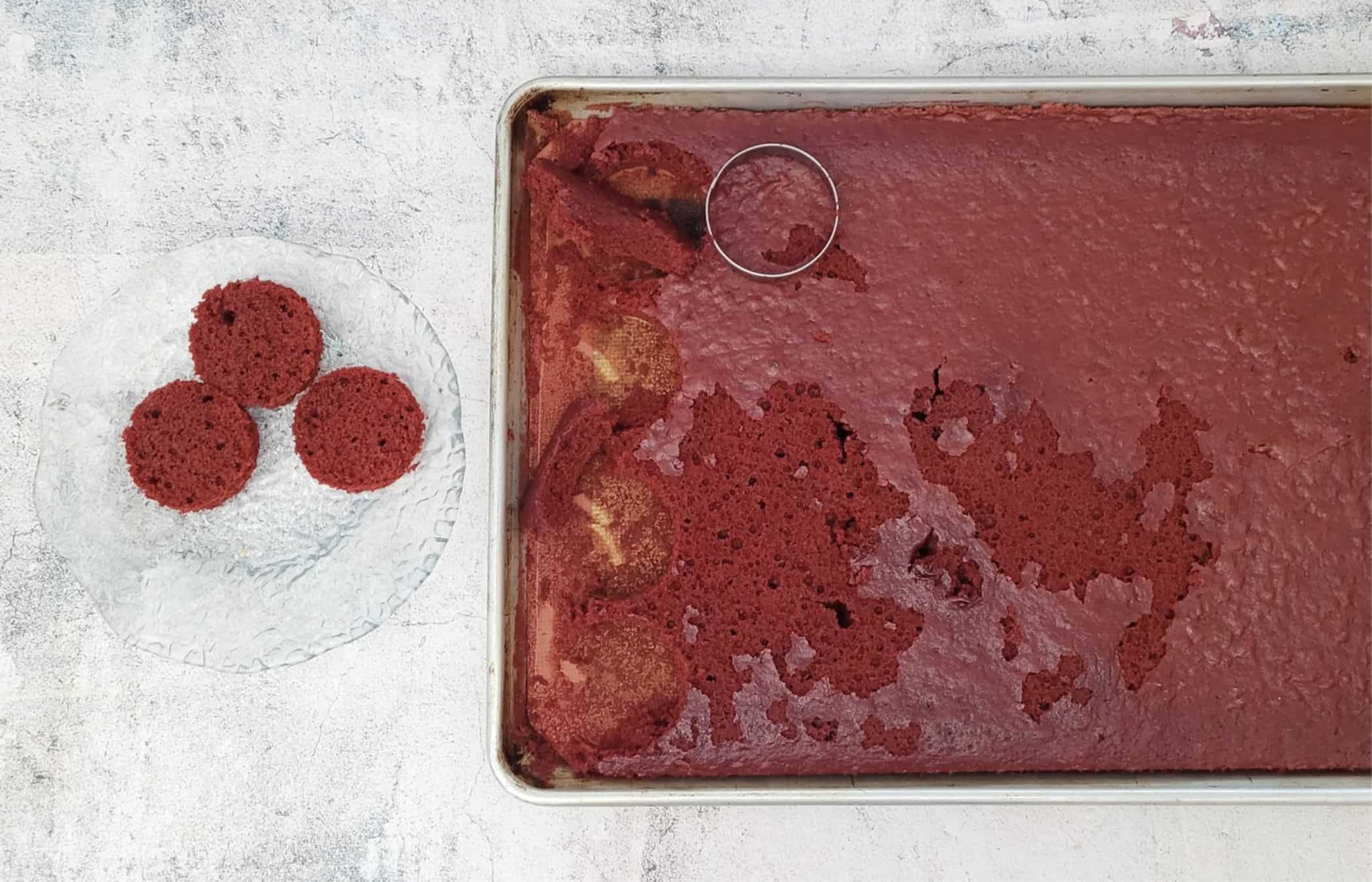 using a round cookie cutter to cut discs of red velvet cake