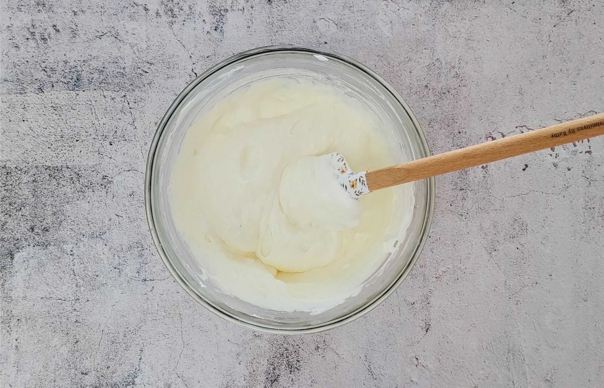 overhead view of whipped cream being folded into cream cheese and sugar mixture