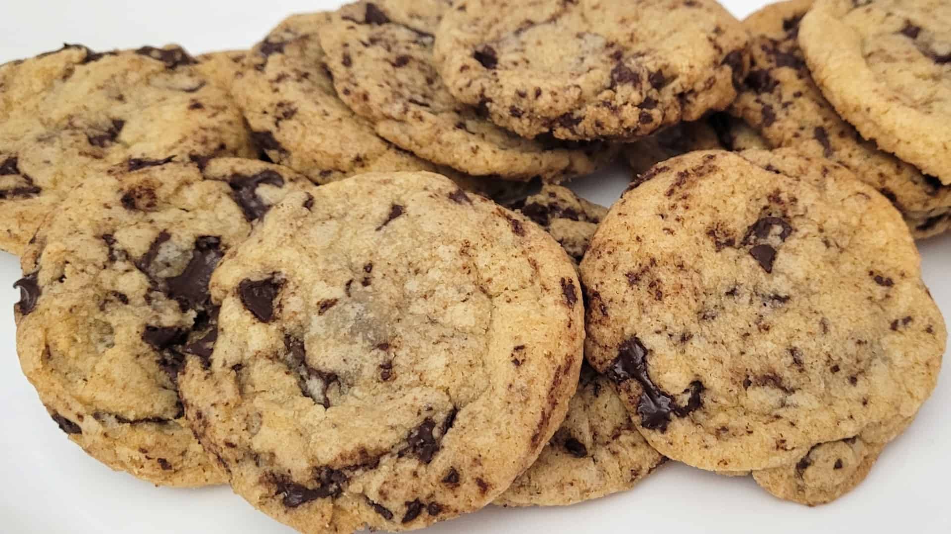 big pile of gluten-free chocolate chip cookies topped with sea salt