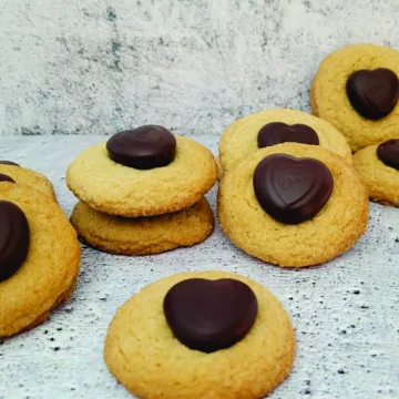 several peanut butter cookies with chocolate hearts placed on top of cookie