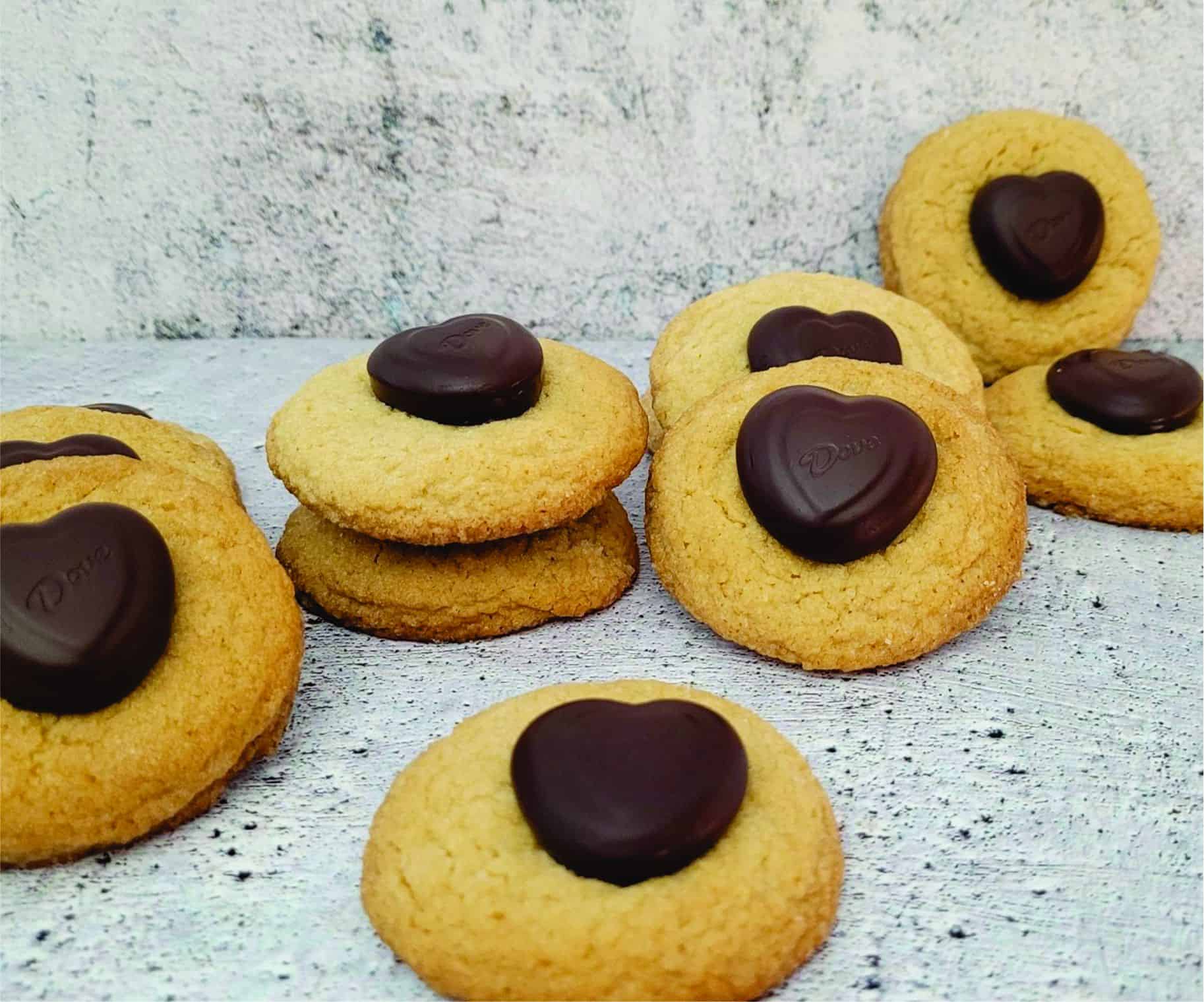 several peanut butter cookies with chocolate hearts placed on top of cookie