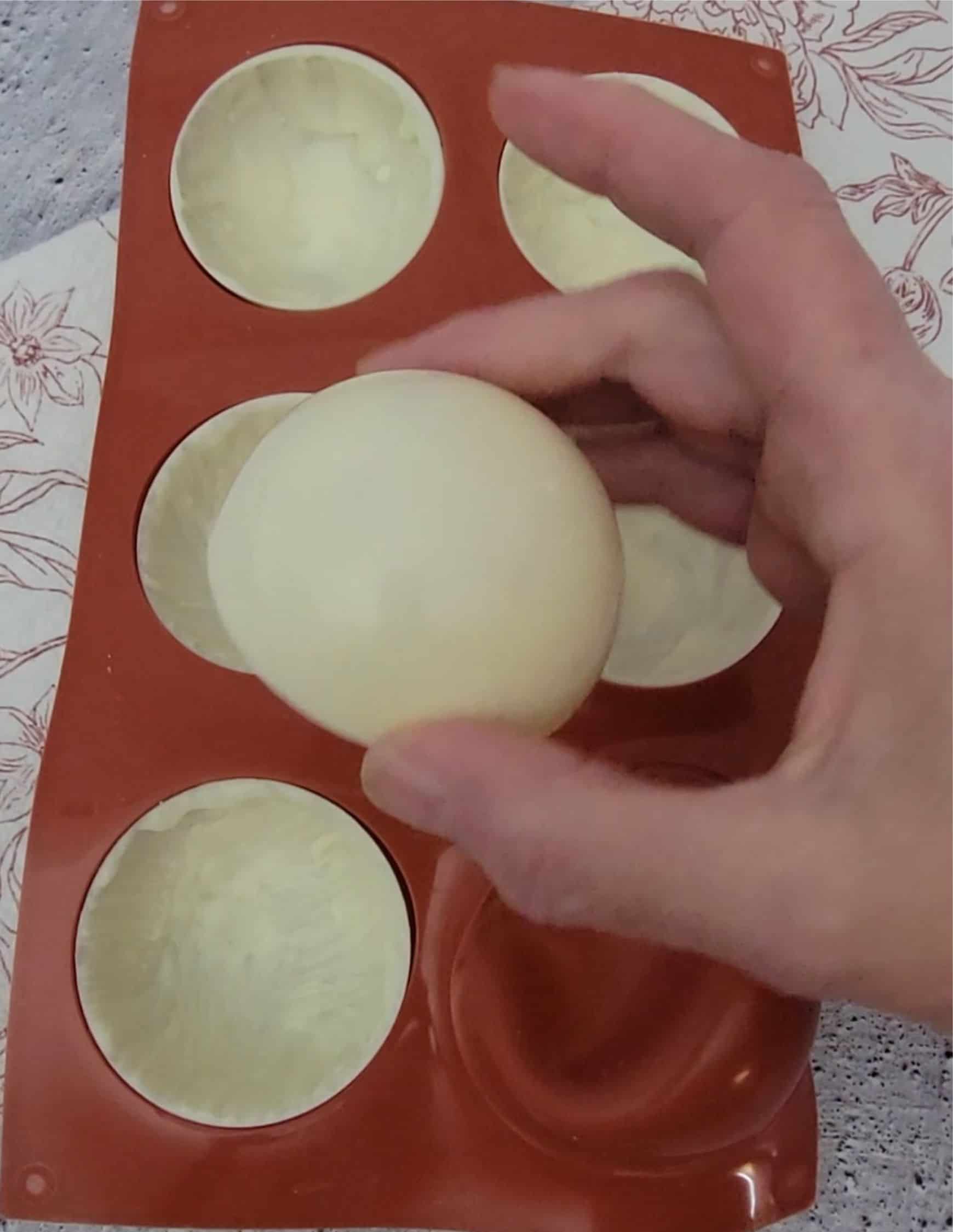 removing white chocolate half spheres out of a silicone mold