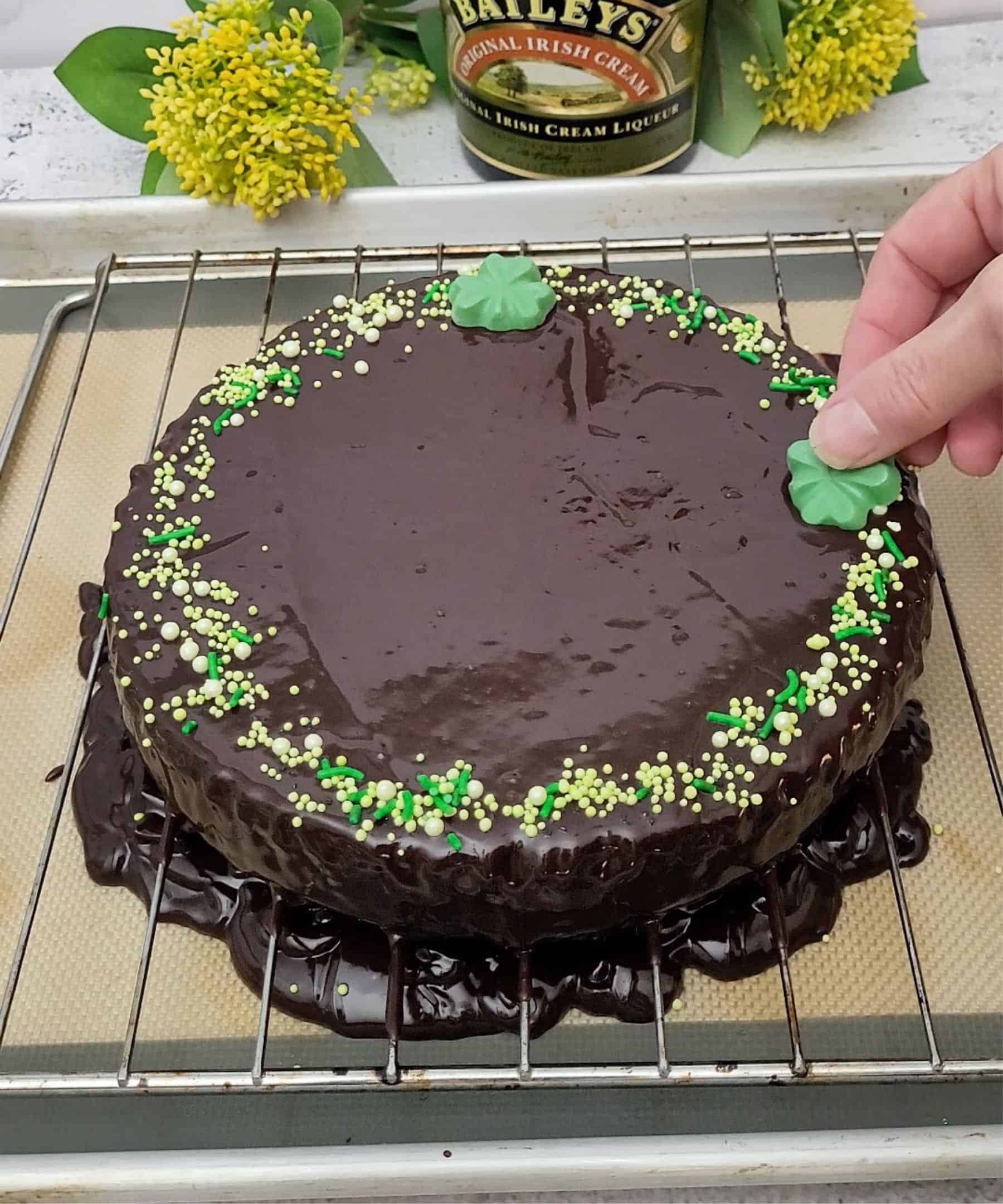 decorating flourless chocolate cake with St Patrick's day decorations including green sprinkles and fondant shamrocks