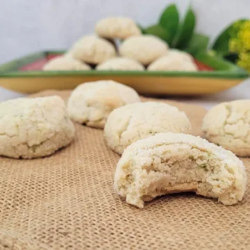 gluten free lime cookies with one cookie bitten into to show the soft inside