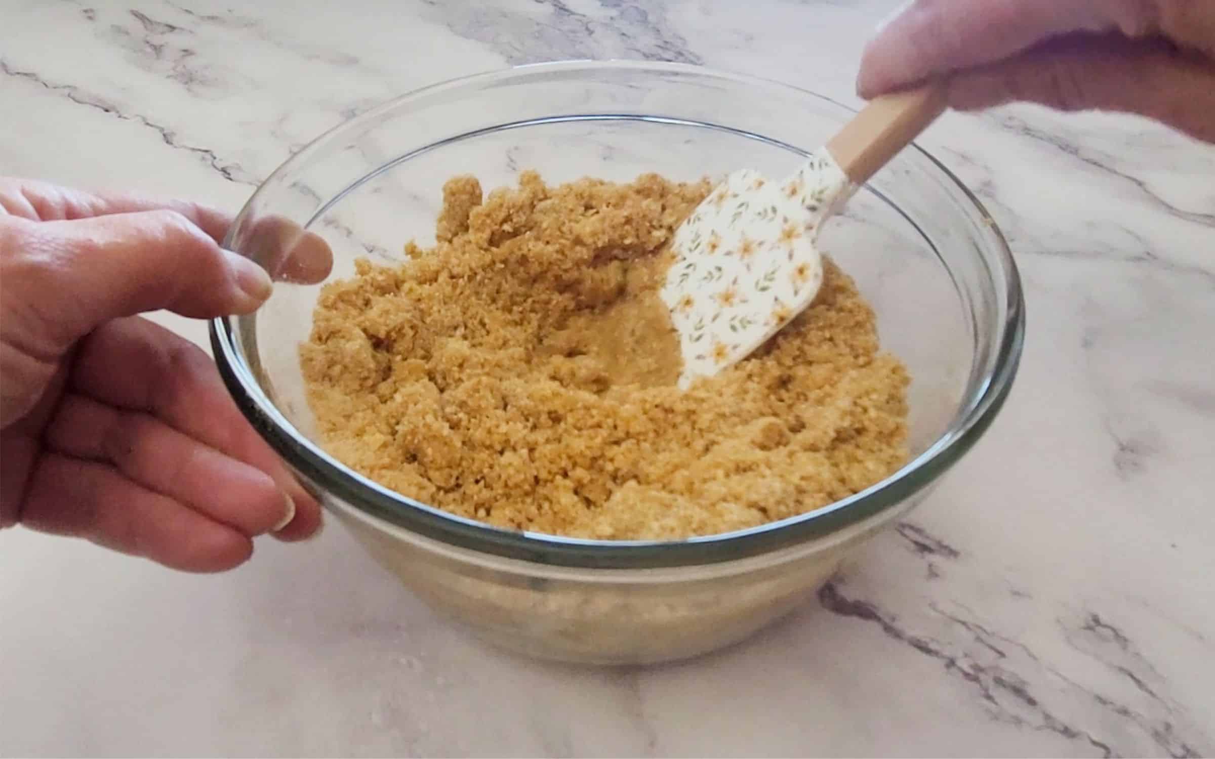 butter added to bowl with graham cracker crumbs and sugar and stirring together to make pie crust