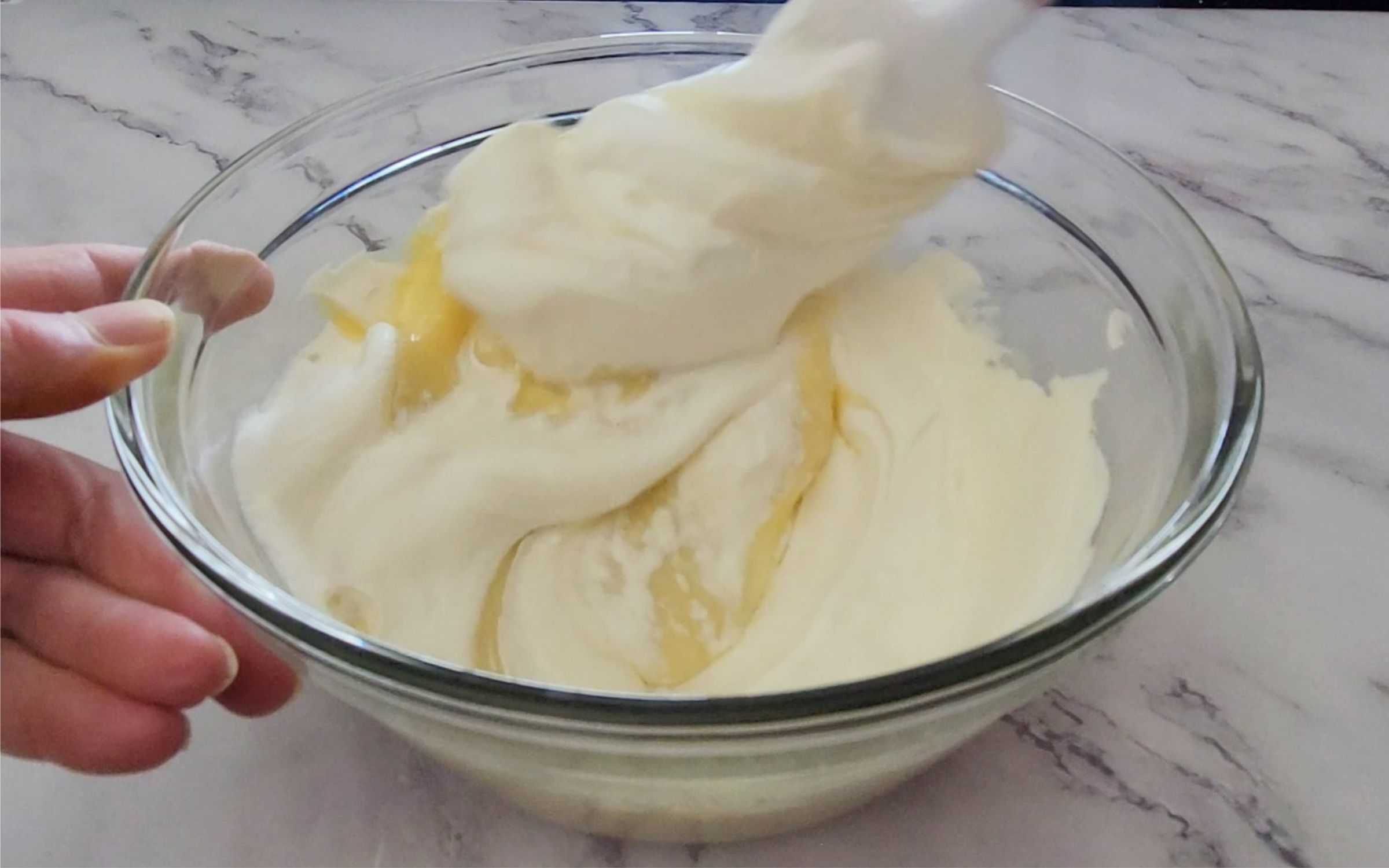 folding whipped topping into bowl with lemon cream pie filling