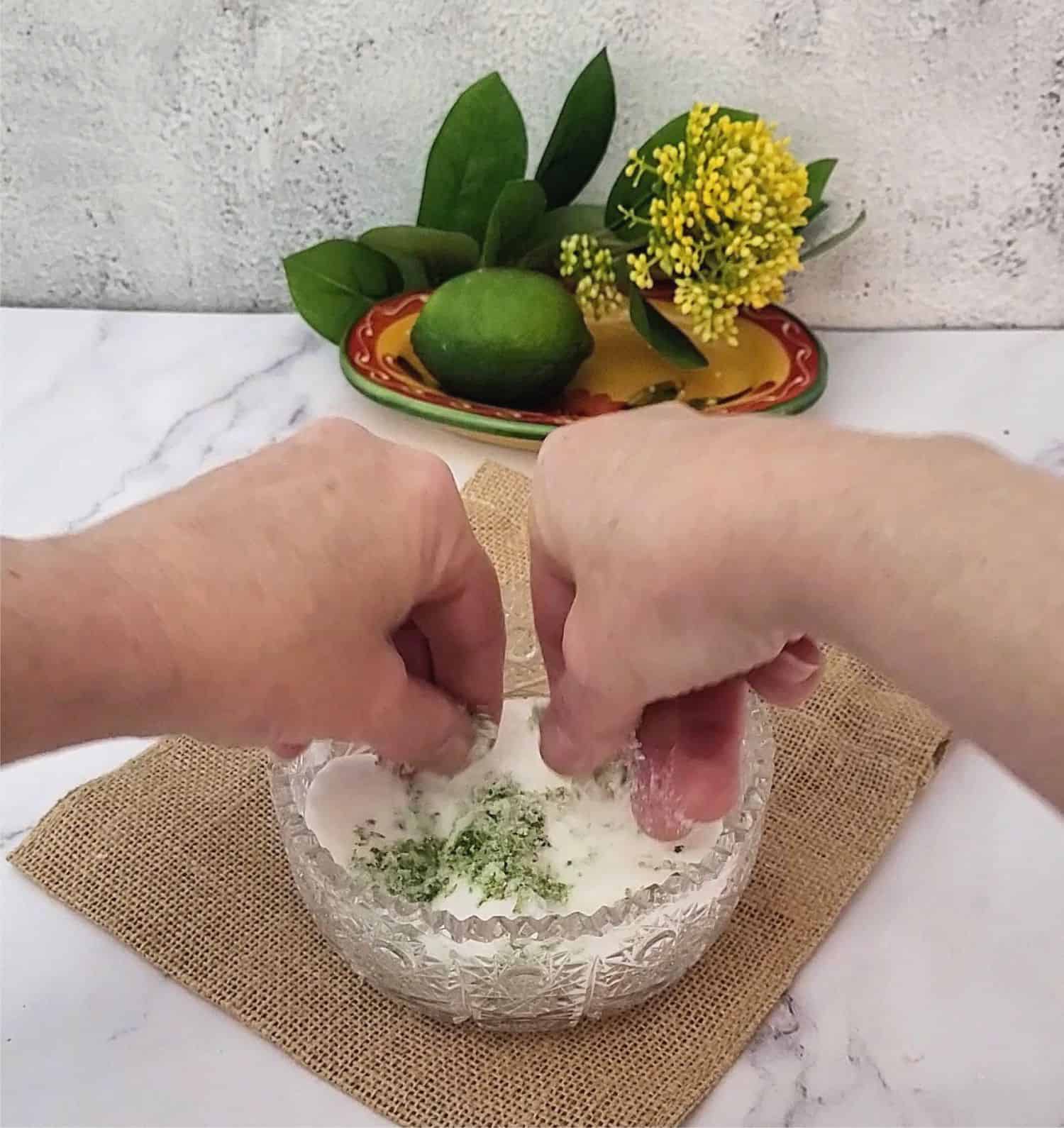 rubbing together lime zest and granulated sugar to make lime flavored sugar to coat cookies