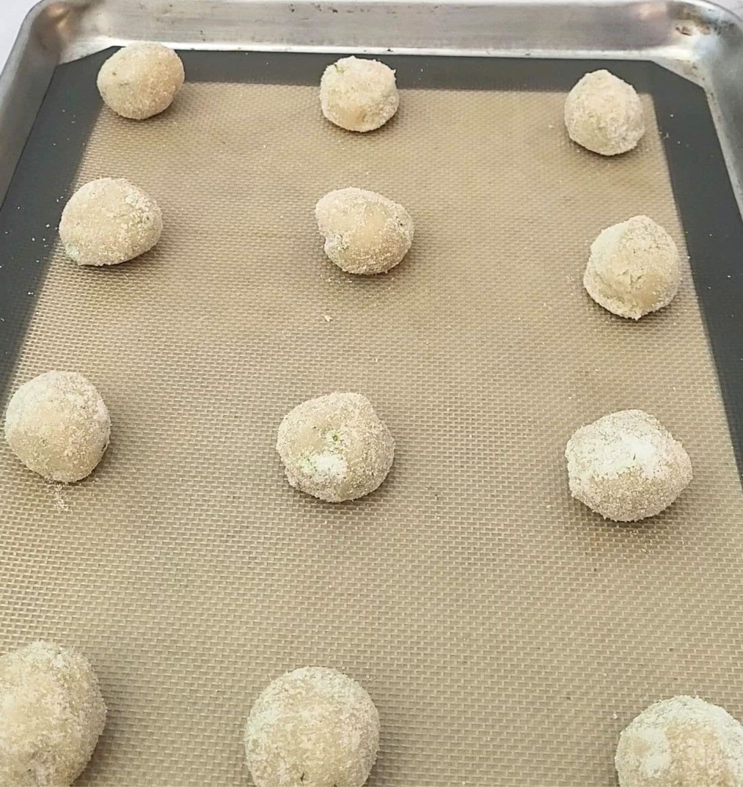 gluten free lime cookie dough balls on a baking sheet ready for baking