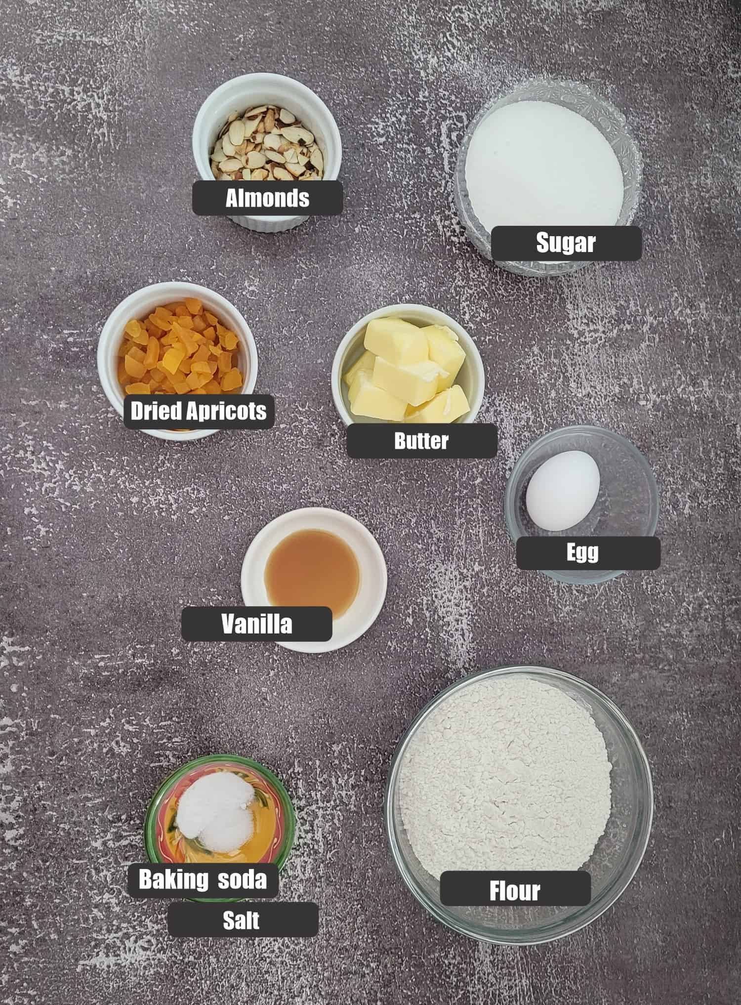 ingredients needed to make apricot almond cookies including apricots, almonds, flour, baking soda, salt, sugar, butter, vanilla and an egg