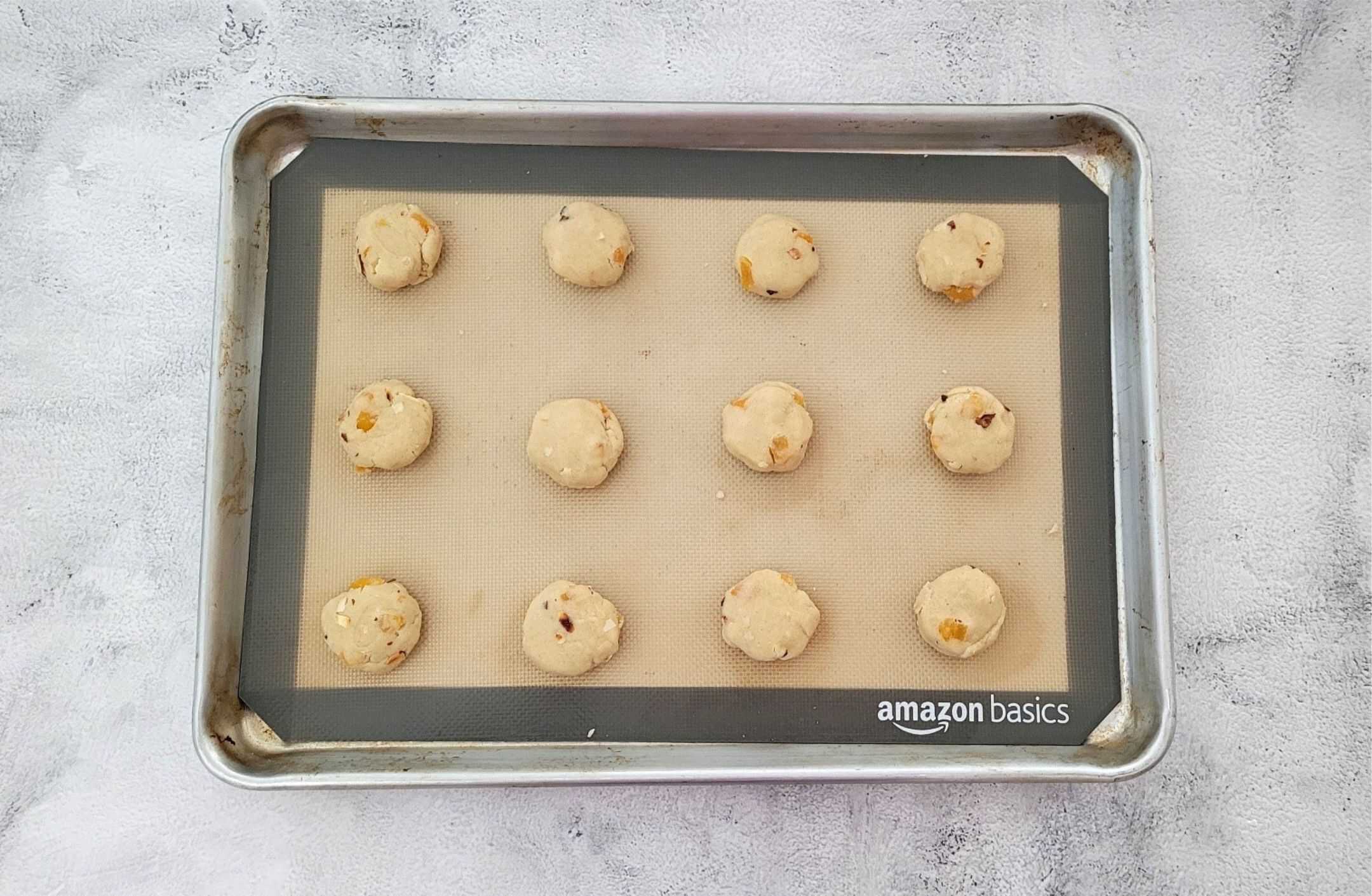 scooped apricot almond cookie dough on a baking pan
