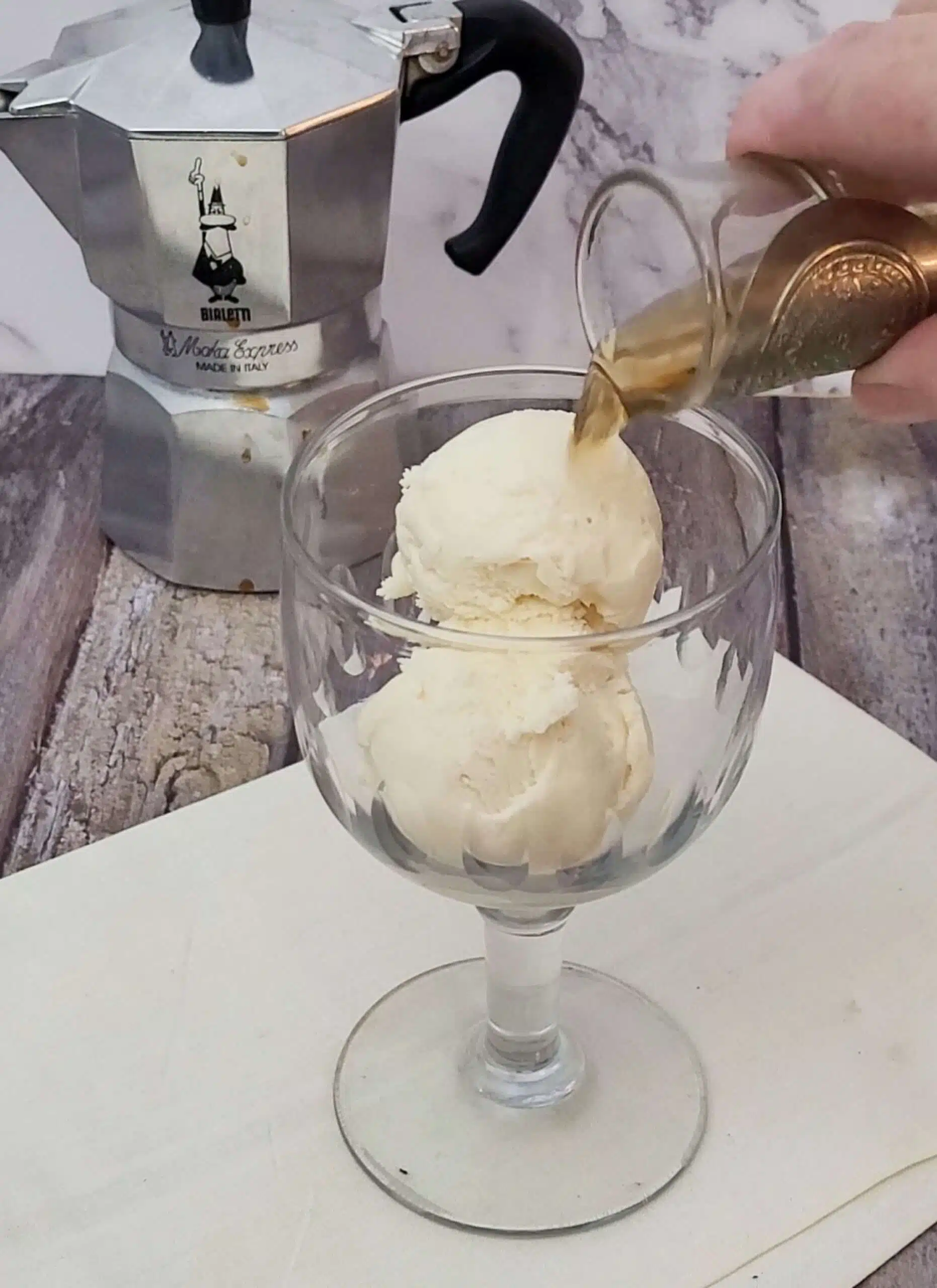 Pouring Amaretto over vanilla ice cream