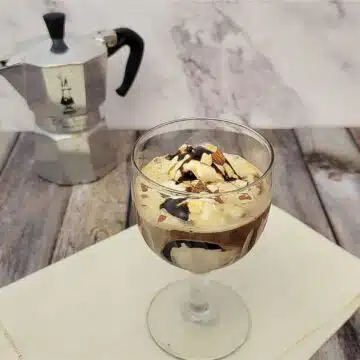 Affogato ice cream dessert with espresso maker in the background