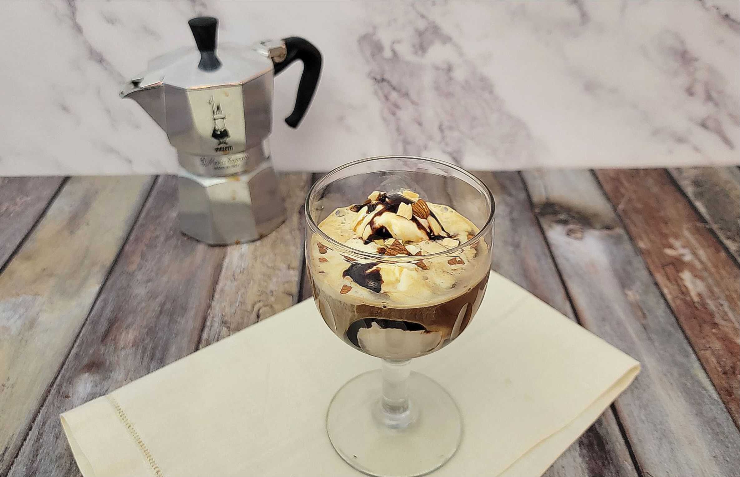 Affogato ice cream dessert with espresso maker in the background