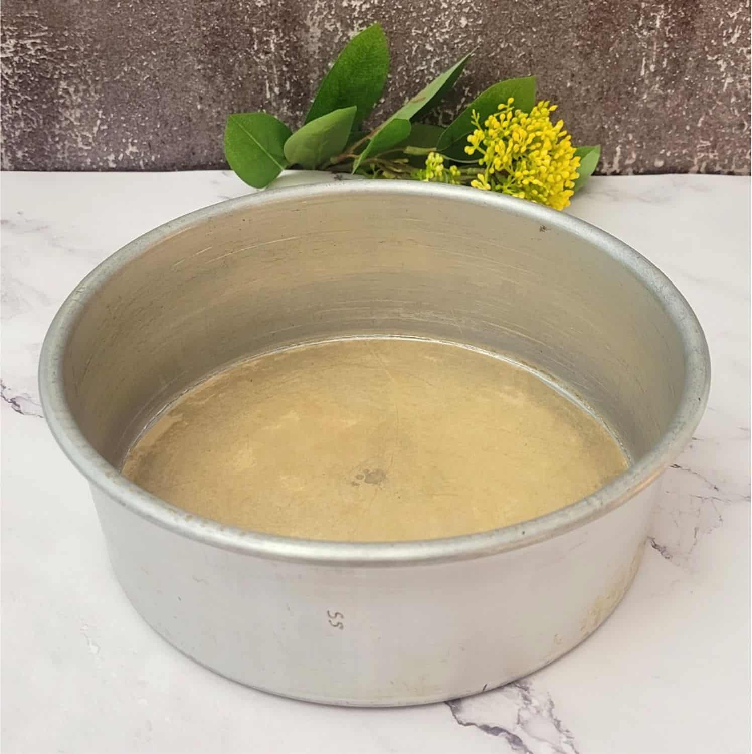 cake pan prepared with butter and a piece of parchment paper