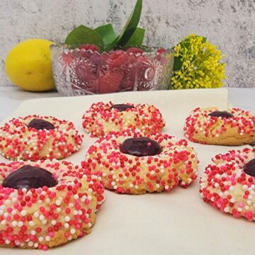 lemon cookies covered with sprinkles and filled with raspberry jam