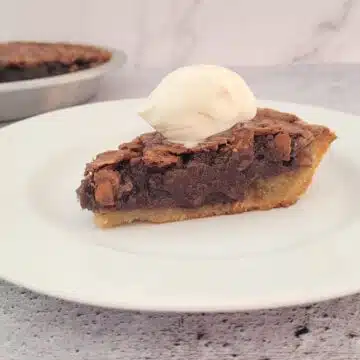 slice of pie on a plate with remainder of pie in the background