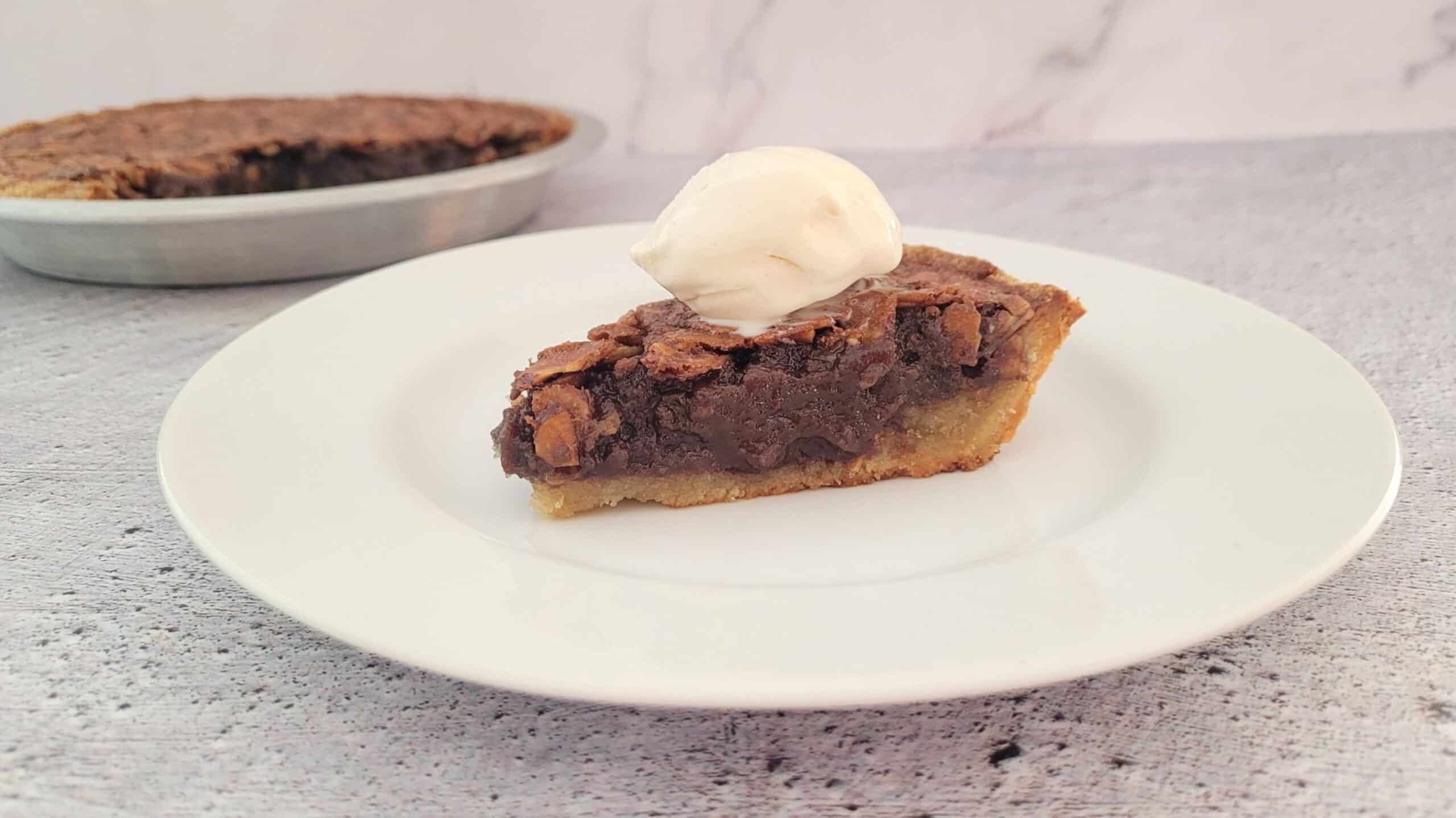 slice of pie on a plate with remainder of pie in the background