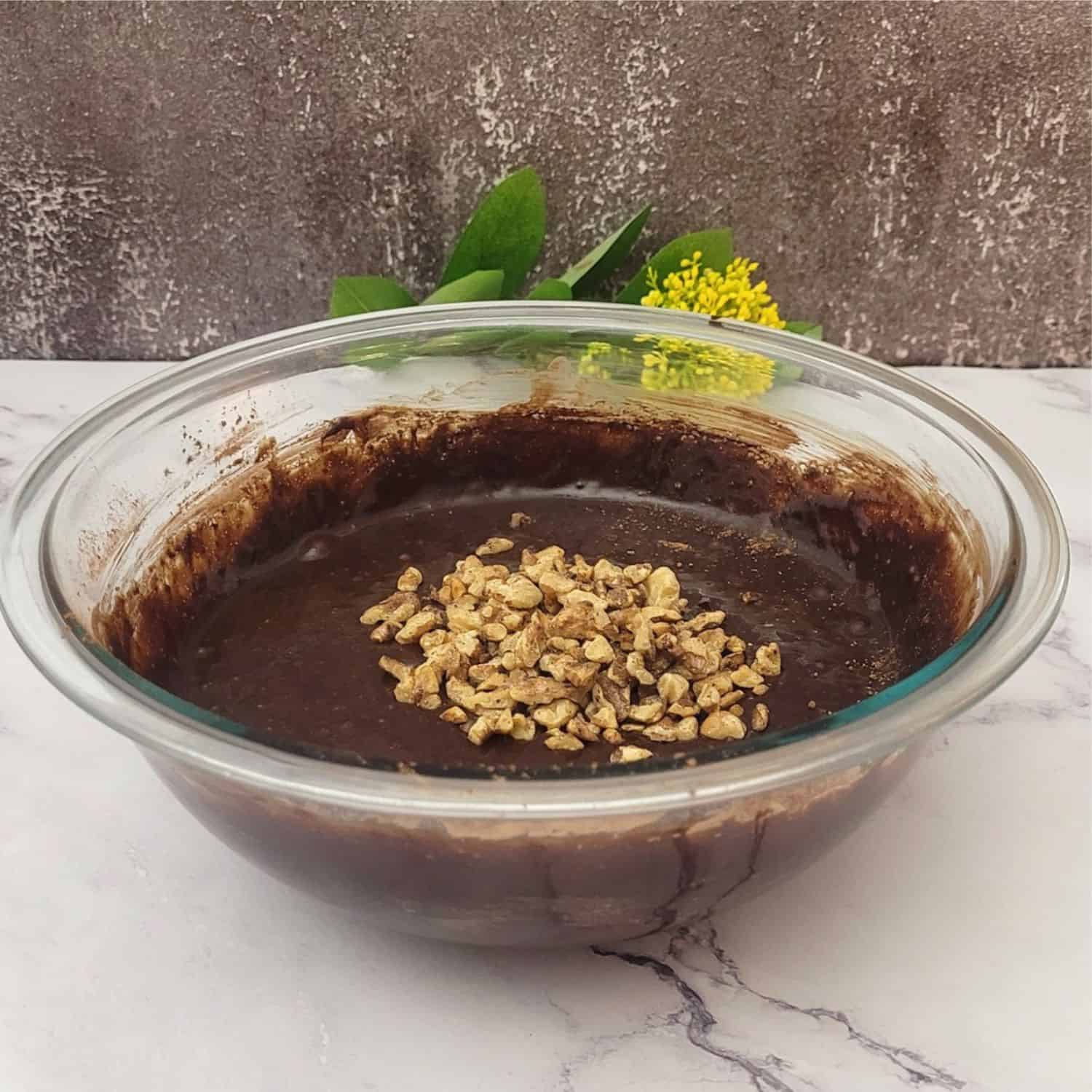 chopped walnuts added to cake batter mixing bowl