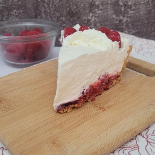slice of no bake raspberry cream pie on a wooden board