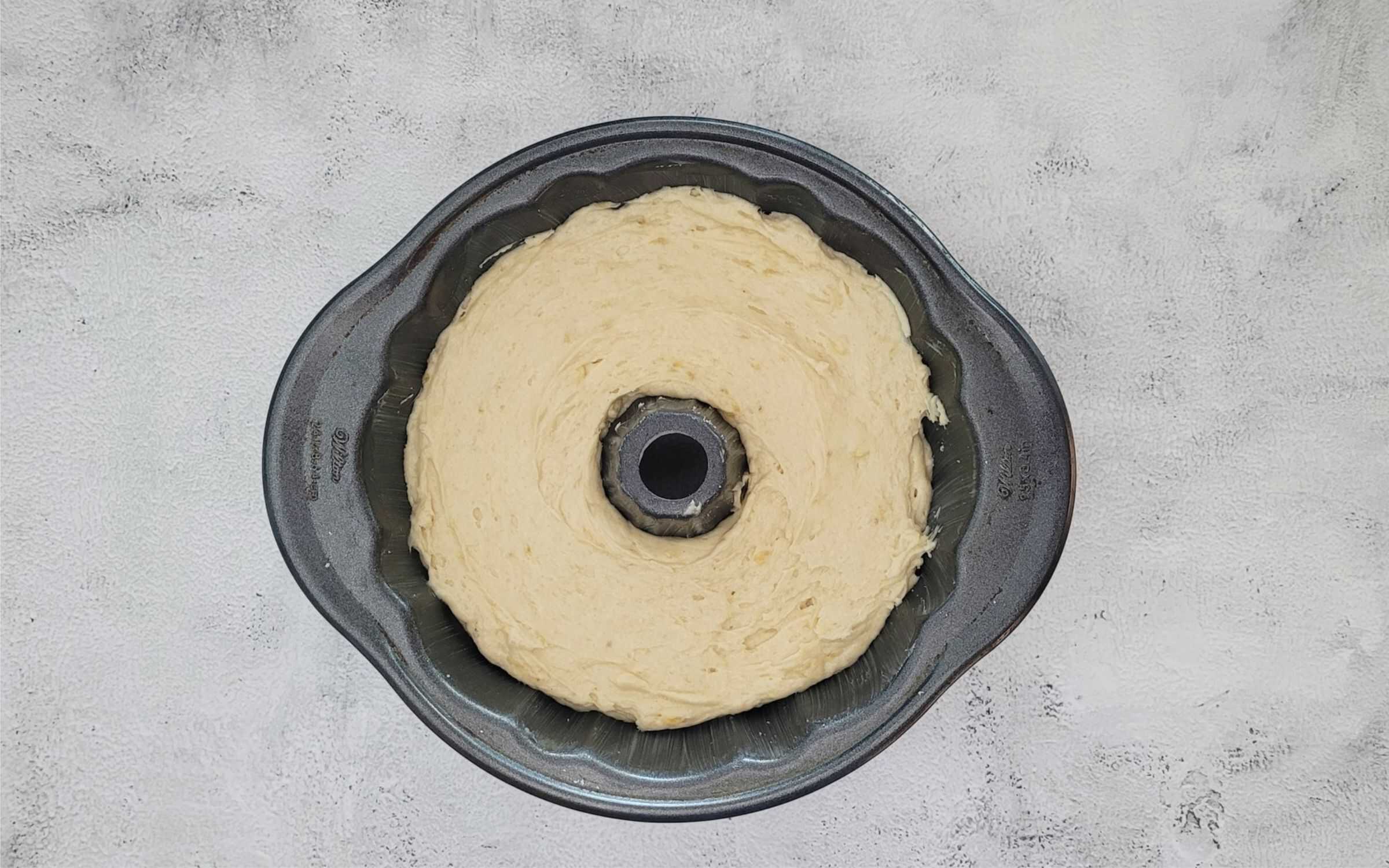 add cake batter to Bundt pan and smooth top prior to baking