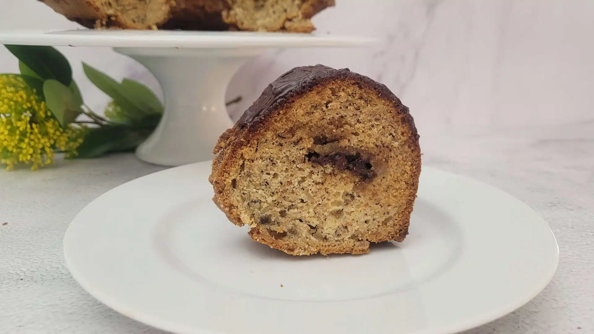 close up view of a slice of banana cake with a chocolate tunnel filling