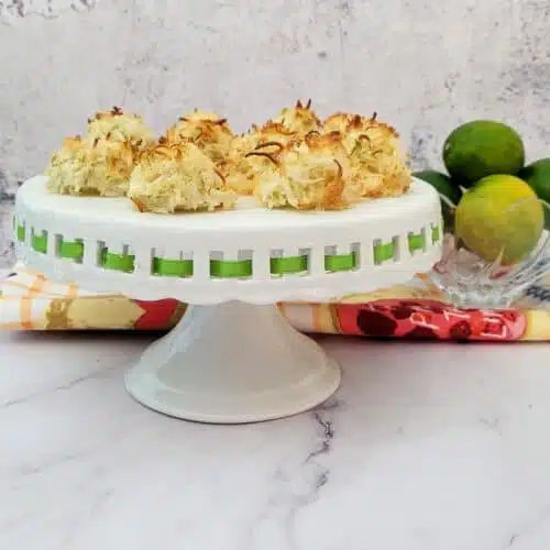 coconut lime macaroons on a stand with limes in the background