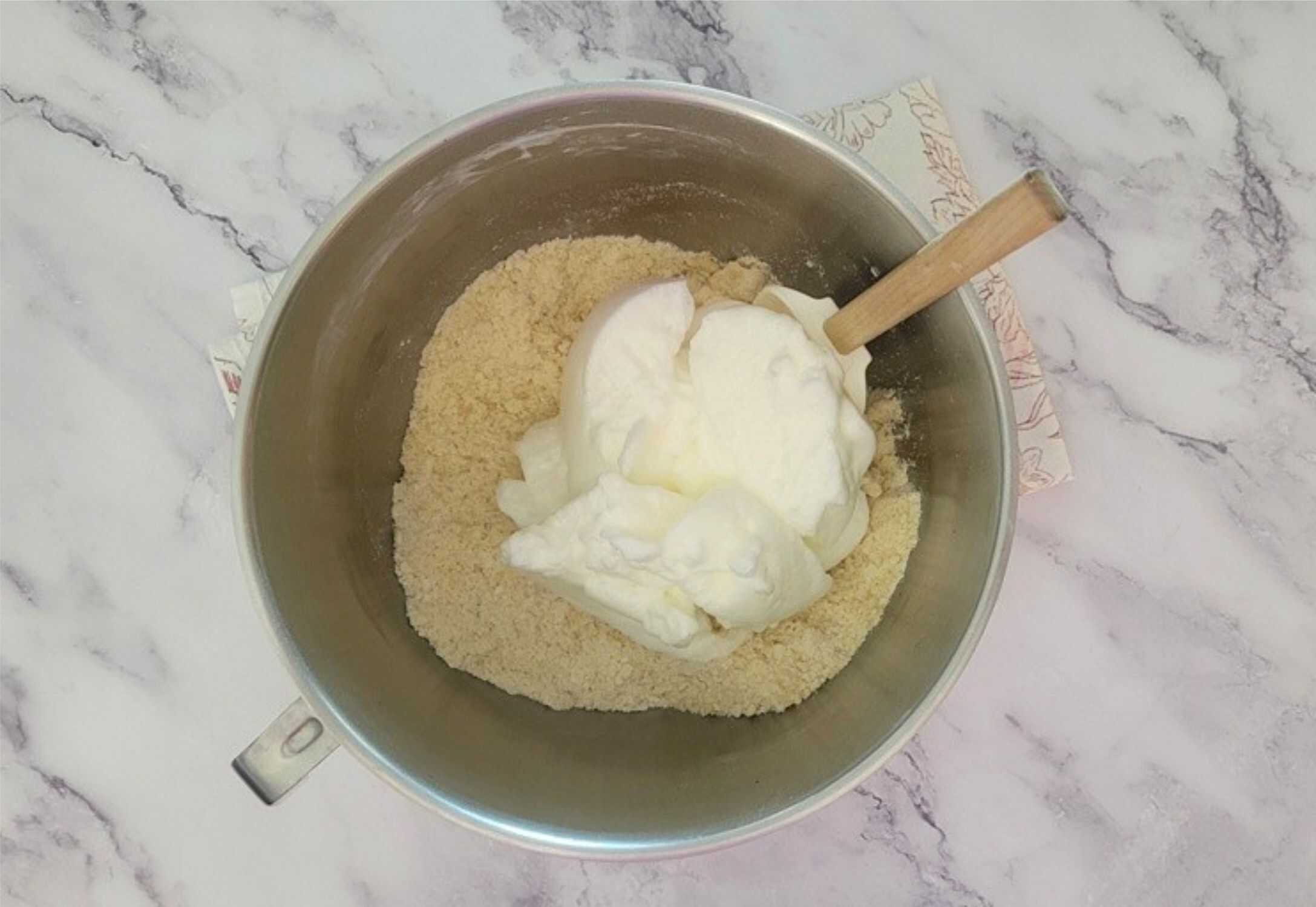 folding whipped egg whites into almond paste mixture