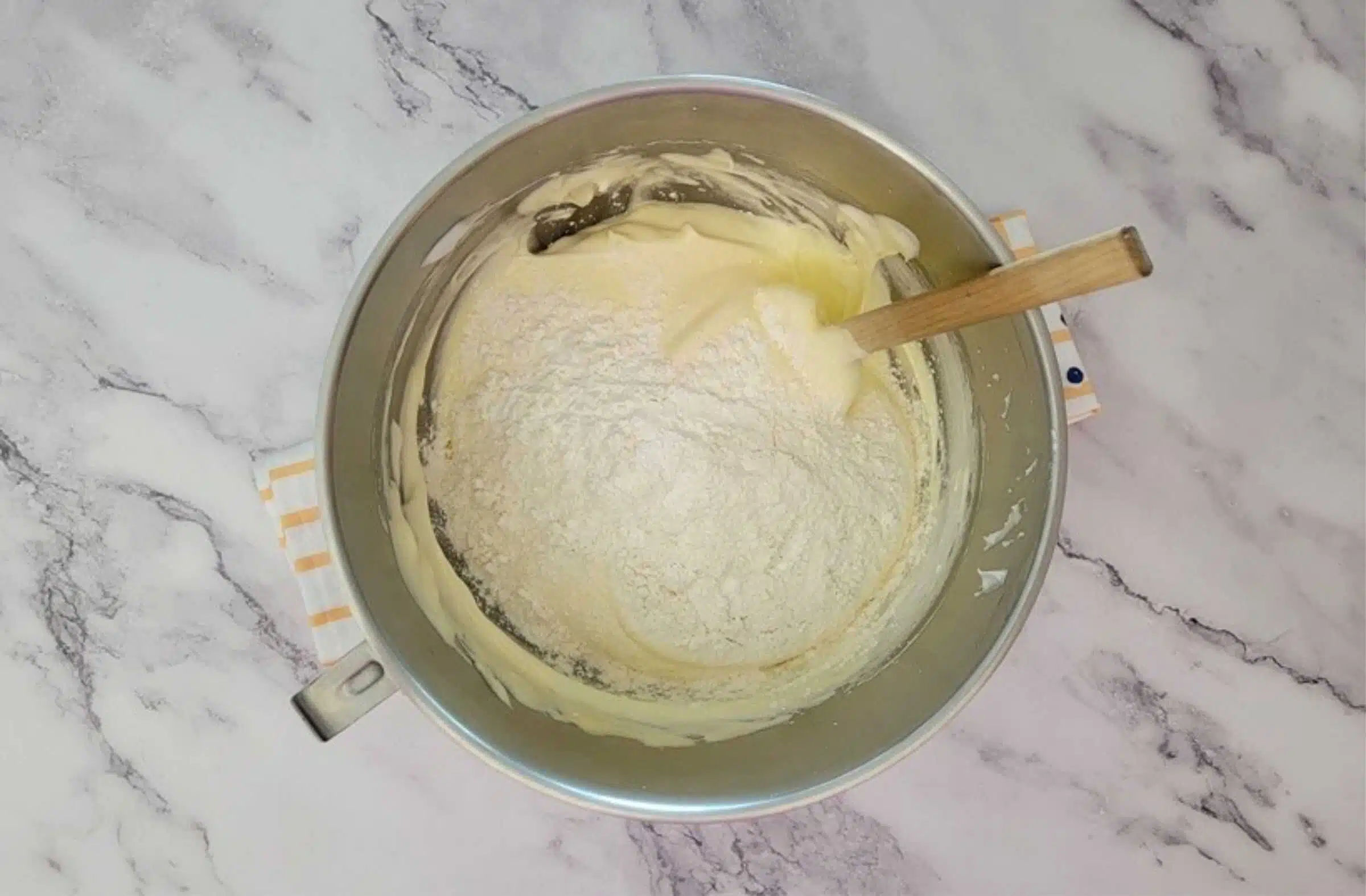 first addition of flour and cornstarch being folded into egg foam to make sponge cake