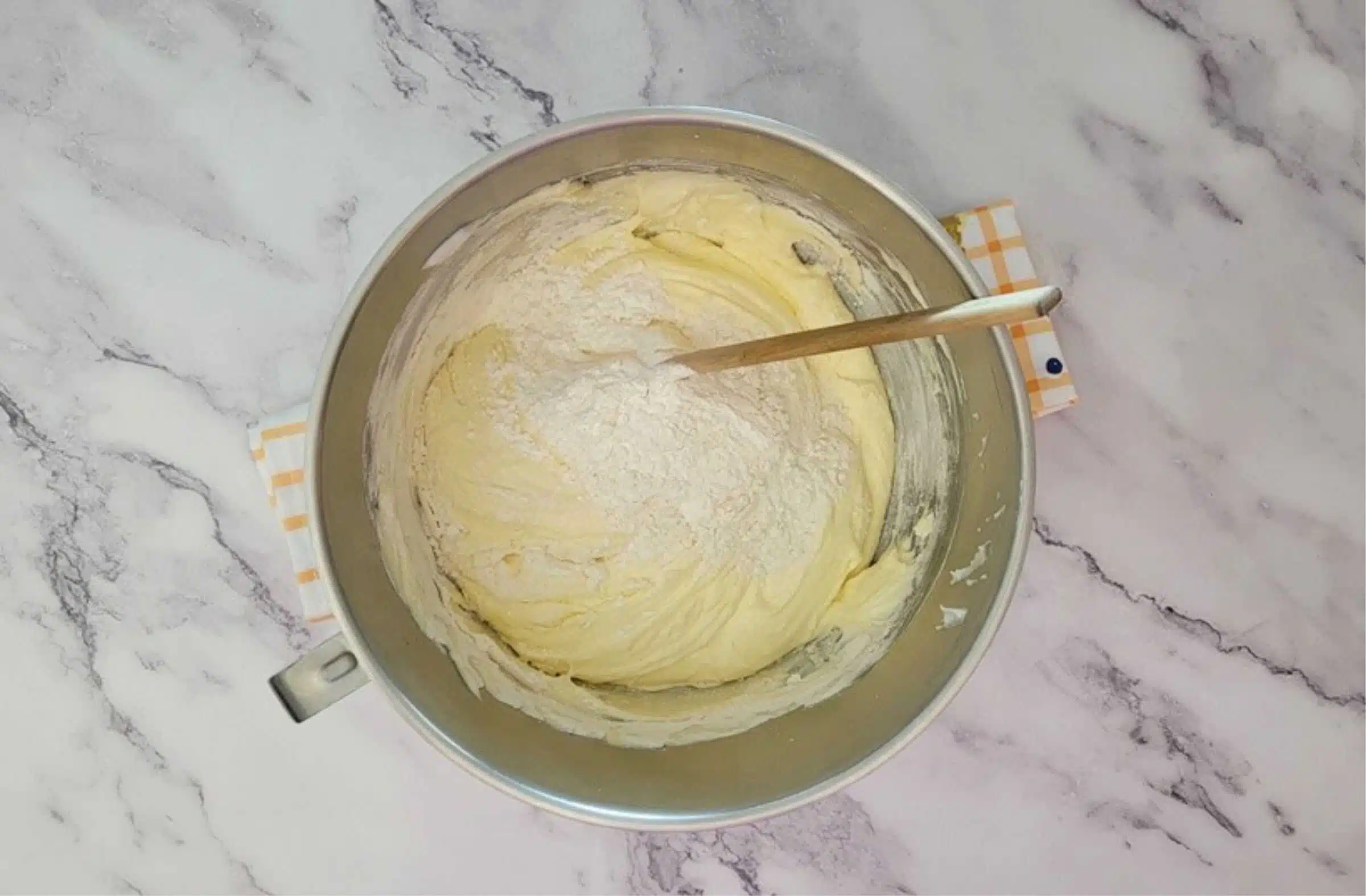 second addition of flour and cornstarch being folded into egg foam to make sponge cake