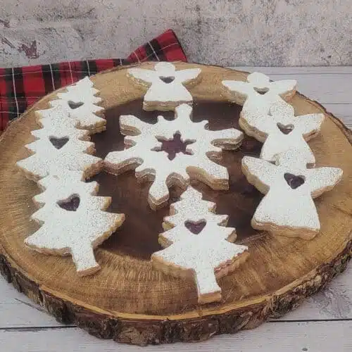 Holiday Linzer cookies on a wooden serving platter